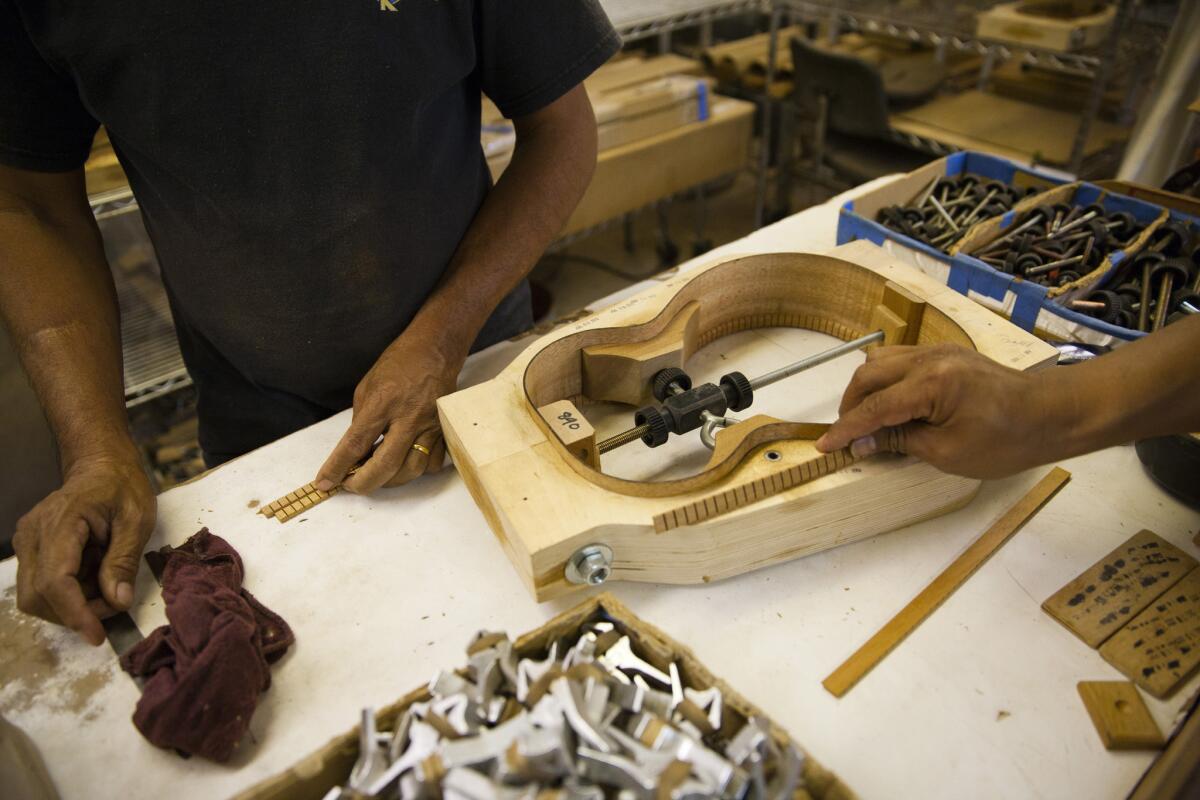 Workers assemble a ukulele at the 100-year-old company based in Honolulu.