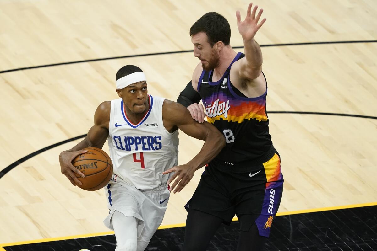 Clippers guard Rajon Rondo drives as Phoenix Suns forward Frank Kaminsky defends.