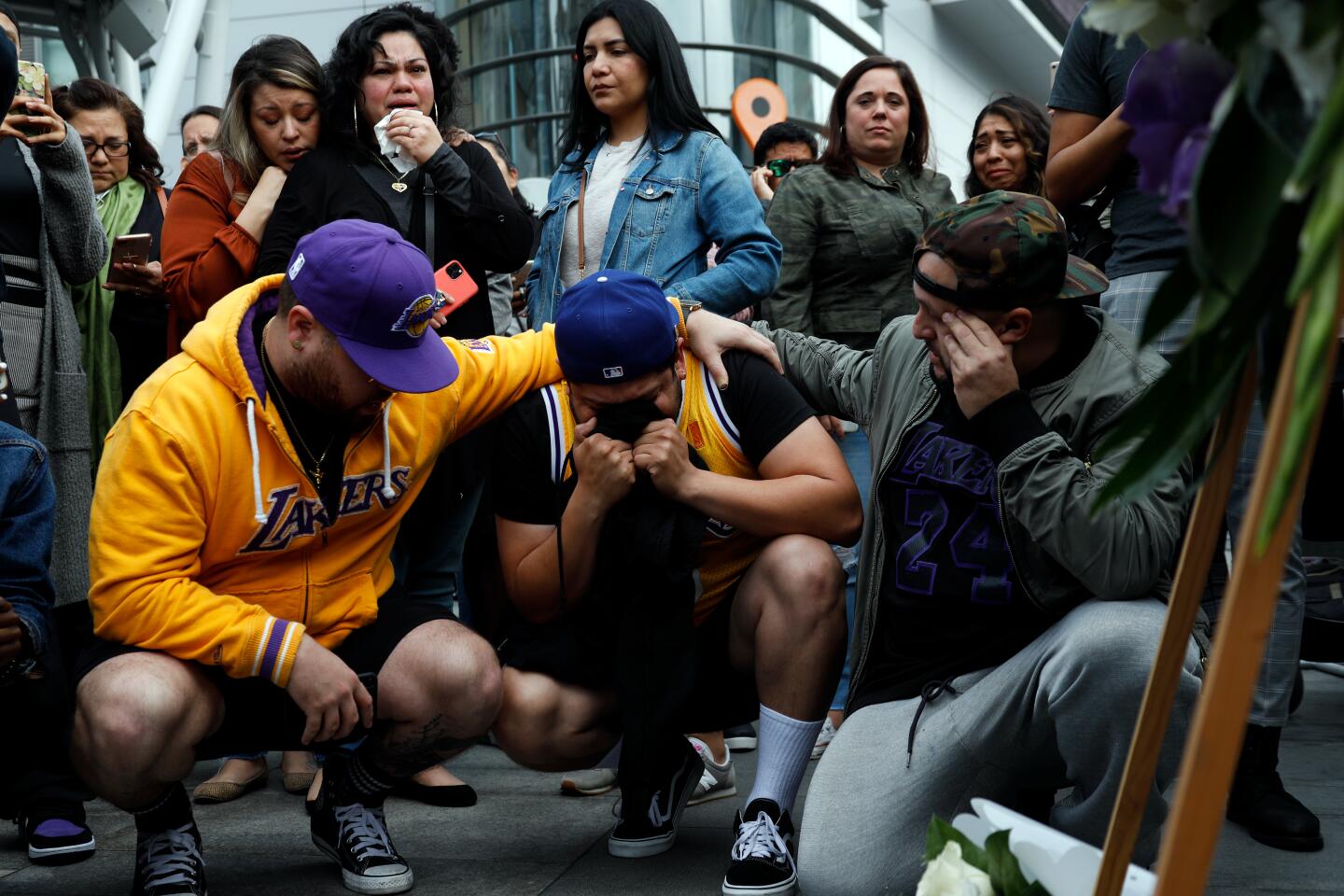 Fans (from left) Alex Fultz, Eddy Rivas and Rene Alfaro gather near a makeshift memorial for Kobe Bryant outside Staples Center on Sunday after learning of his death.