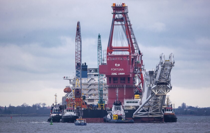 Tugboats get into position on the Russian pipe-laying vessel Fortuna in the port of Wismar, Germany. 