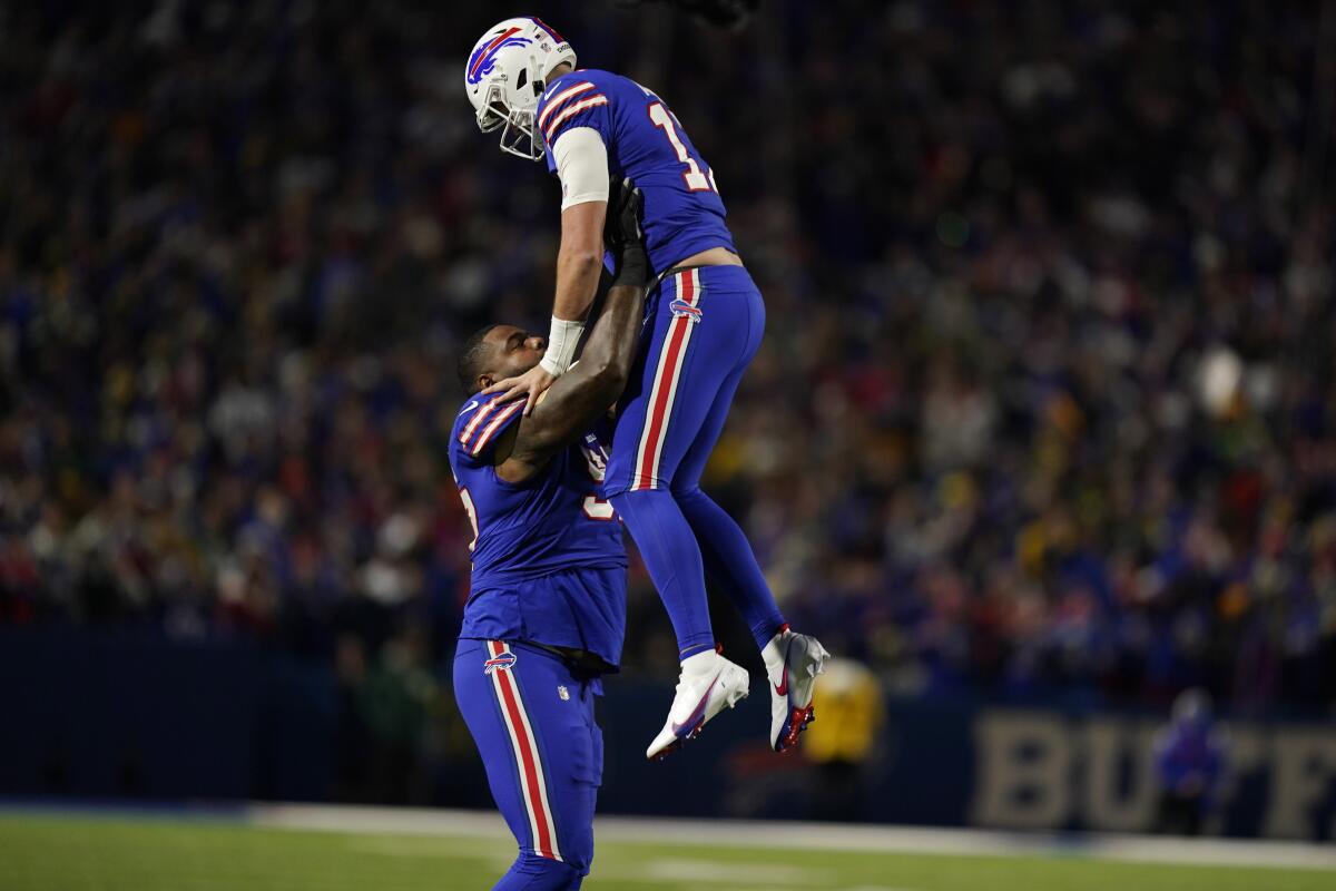 Buffalo Bills quarterback Josh Allen (17) is lifted by Buffalo Bills defensive tackle Jordan Phillips (97) after throwing a touchdown pass during the first half of an NFL football game against the Green Bay Packers Sunday, Oct. 30, 2022, in Orchard Park. (AP Photo/Seth Wenig)