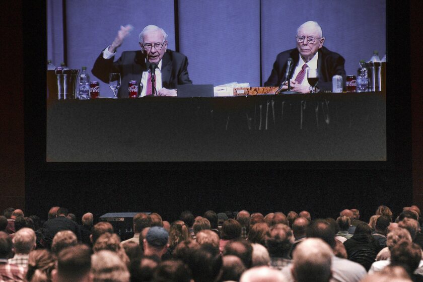 FILE - Shareholders in overflow rooms watch on a big screen as Berkshire Hathaway Chairman and CEO Warren Buffett, left, and Vice Chairman Charlie Munger preside over the annual Berkshire Hathaway shareholders meeting in Omaha, Neb., Saturday, May 4, 2019. Buffett’s company plans to hold its annual shareholders meeting that used to routinely attract more than 40,000 people in person this spring for the first time since the pandemic began. The meeting will be held at a downtown Omaha arena on April 30, 2022. (AP Photo/Nati Harnik, File)
