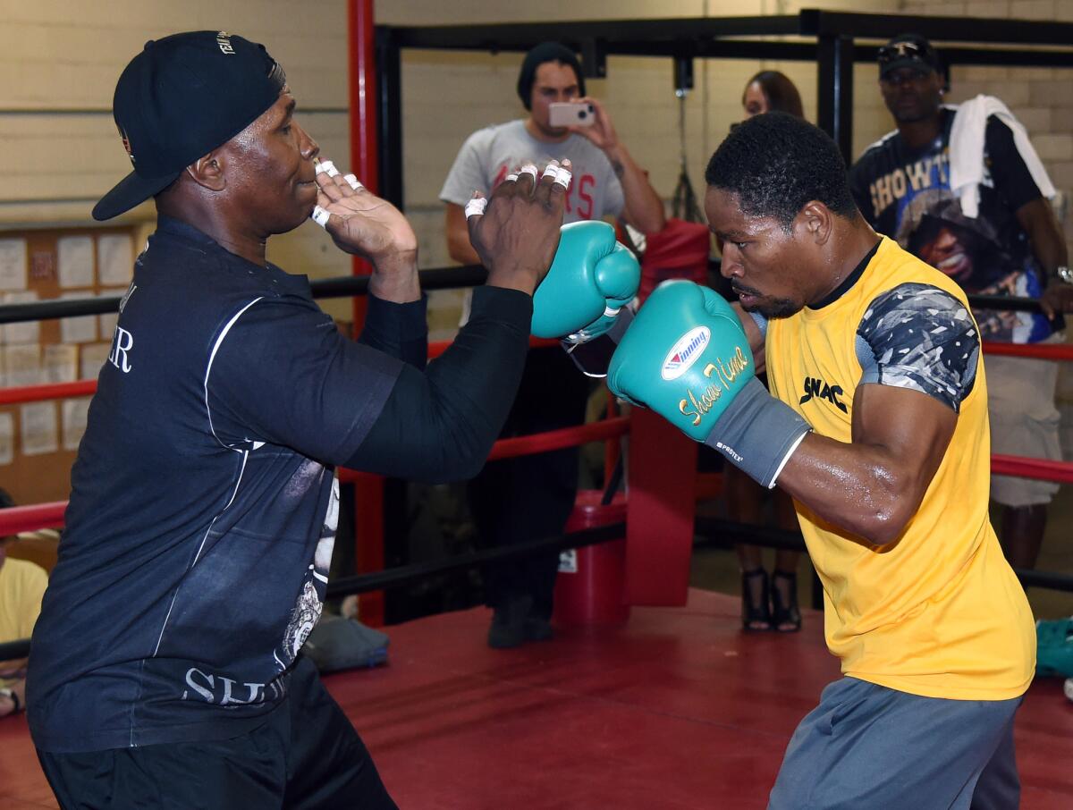 IBF welterweight champion Shawn Porter, right, spars with his father and trainer, Kenneth Porter, during a media workout at Barry's Gym on Aug. 6 in Las Vega.