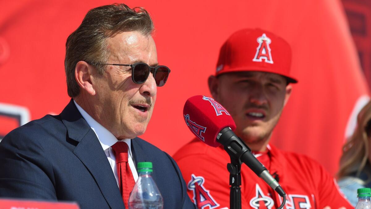 Mike Trout of the Angels looks on as owner Arte Moreno talks during Sunday's press conference at Angel Stadium.
