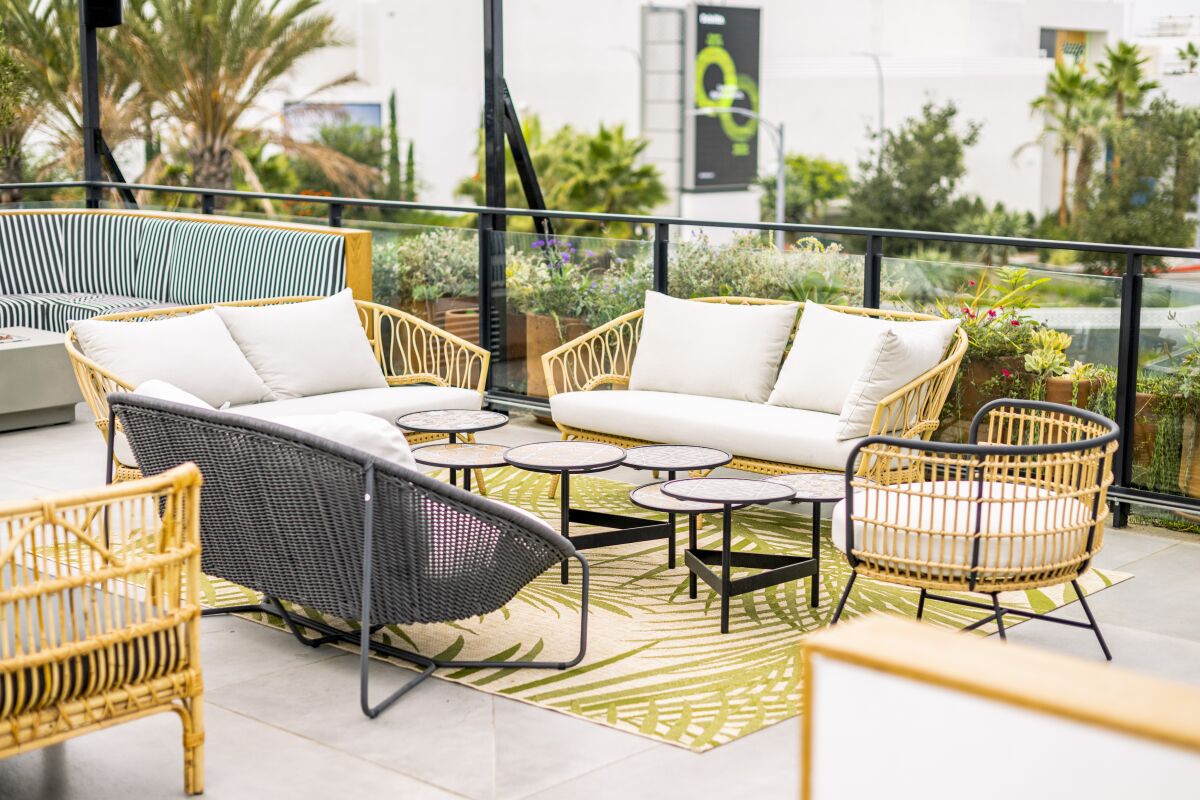 The third-floor rooftop at Cork & Batter features comfortable couches, wicker seats and fire pits. 