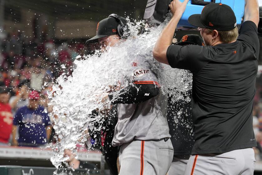 El pitcher de los Gigantes de San Francisco es bañado por sus compañeros tras completar su sin hit ante los Rojos de Cincinnati el viernes 2 de agosto del 2024. (AP Foto/Jeff Dean)