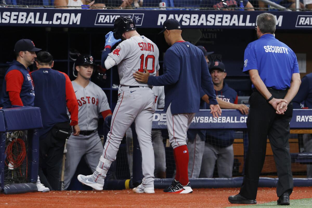Boston Red Sox manager Alex Cora, right, walks the Red Sox's Trevor Story off the field against the Tampa Bay Rays during the fifth inning of a baseball game Tuesday July 12, 2022, in St. Petersburg, Fla. (AP Photo/Scott Audette)