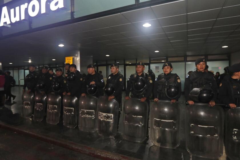 Anti-riot police stand guard at the La Aurora International Airport in Guatemala City, Sunday, Jan. 6, 2019. The Guatemalan government banned the entry of Yilen Osorio, an official of the International Commission Against Impunity in Guatemala (CICIG) and keeps it in the facilities of the La Aurora International Airport, despite the fact that the Constitutional Court ordered that they be granted visas and access to the members of the organism. (AP Photo/Moises Castillo)