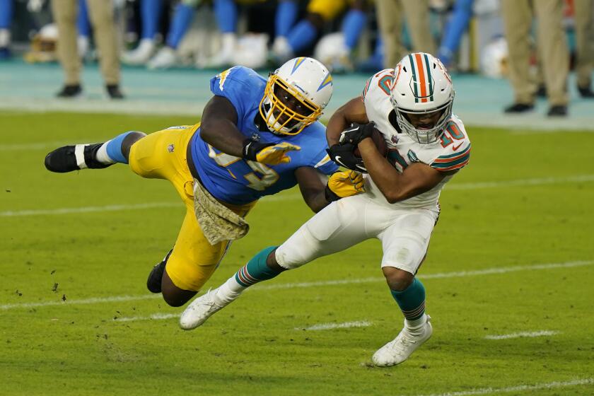 Los Angeles Chargers defensive tackle Justin Jones (93) attempts to tackle Miami Dolphins running back Malcolm Perry (10) during the first half of an NFL football game, Sunday, Nov. 15, 2020, in Miami Gardens, Fla. (AP Photo/Wilfredo Lee)