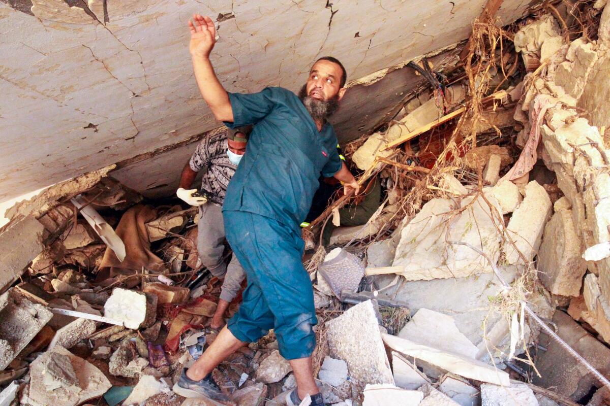 Man amid rubble from flood in Derna, Libya