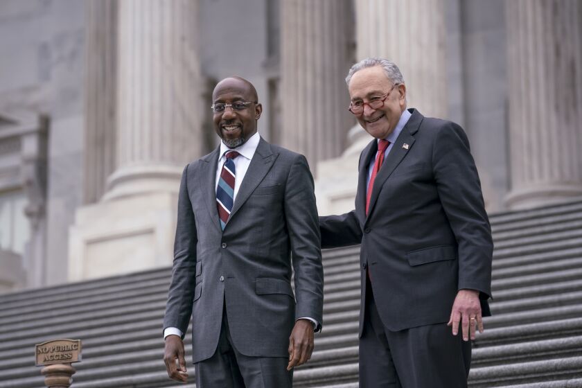 Sen. Raphael Warnock, D-Ga., left, is welcomed back to the Capitol by Senate Majority Leader Chuck Schumer, D-N.Y., after Warnock defeated Republican challenger Herschel Walker in a runoff election in Georgia last night, in Washington, Wednesday, Dec. 7, 2022. The Democrats' new outright majority of 51-49 in the Senate means Schumer will no longer have to negotiate a power-sharing deal with Republicans and won't have to rely on Vice President Kamala Harris to break as many tie votes. (AP Photo/J. Scott Applewhite)