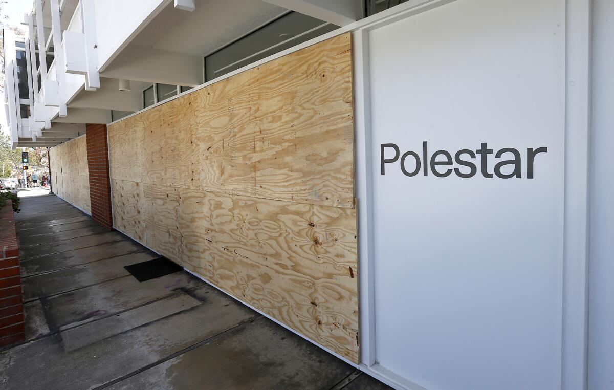 Plywood covers the Laguna Beach Polestar car showroom window panes.