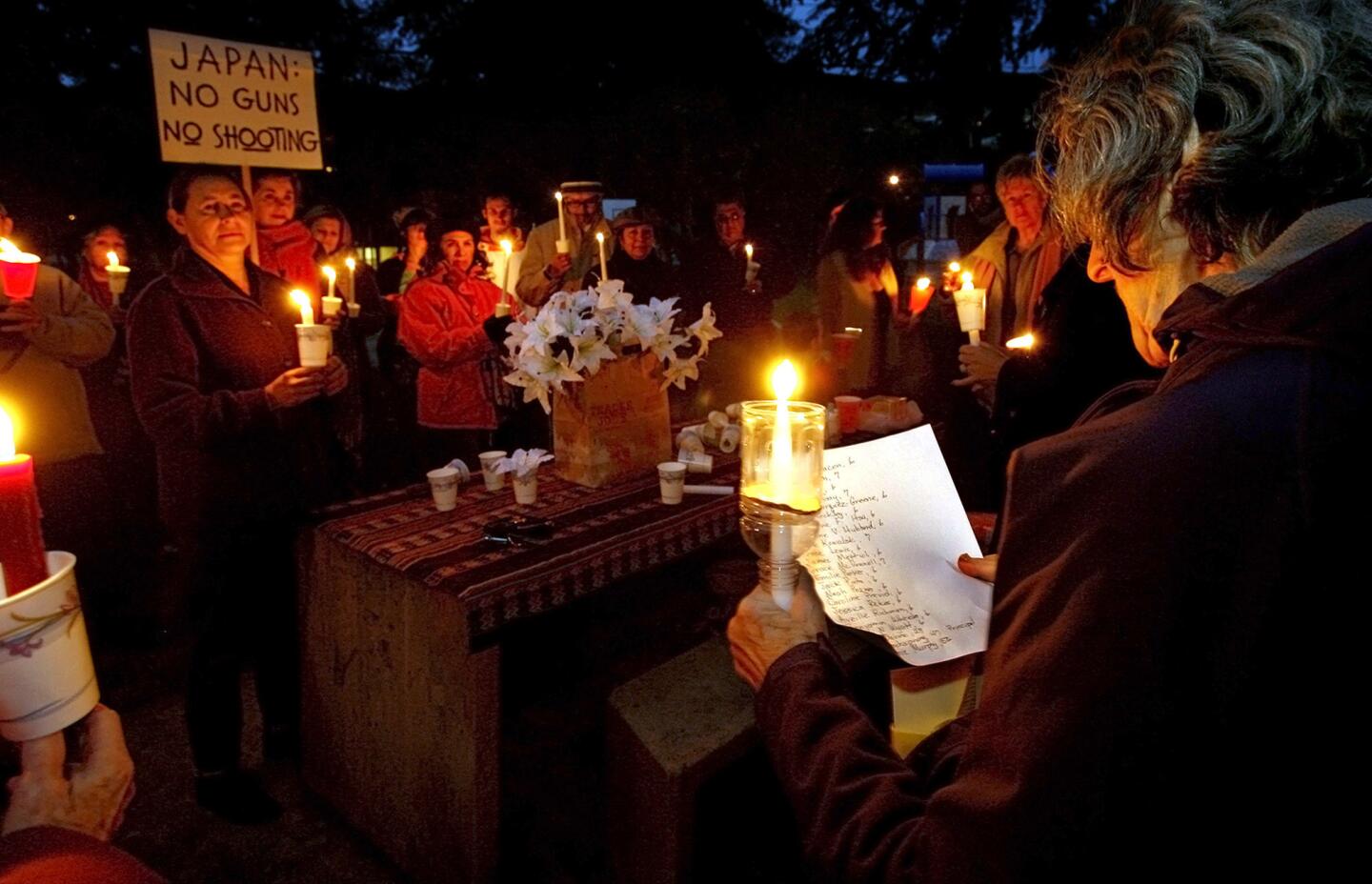 Abby Cohen of Altadena, right, read off the names of those killed at Newtown's (Connecticut) Sandy Hook Elementary School during candlelight vigil at Glenoaks Park in Glendale on Saturday evening, December 15, 2012. About 60 people came to the vigil.