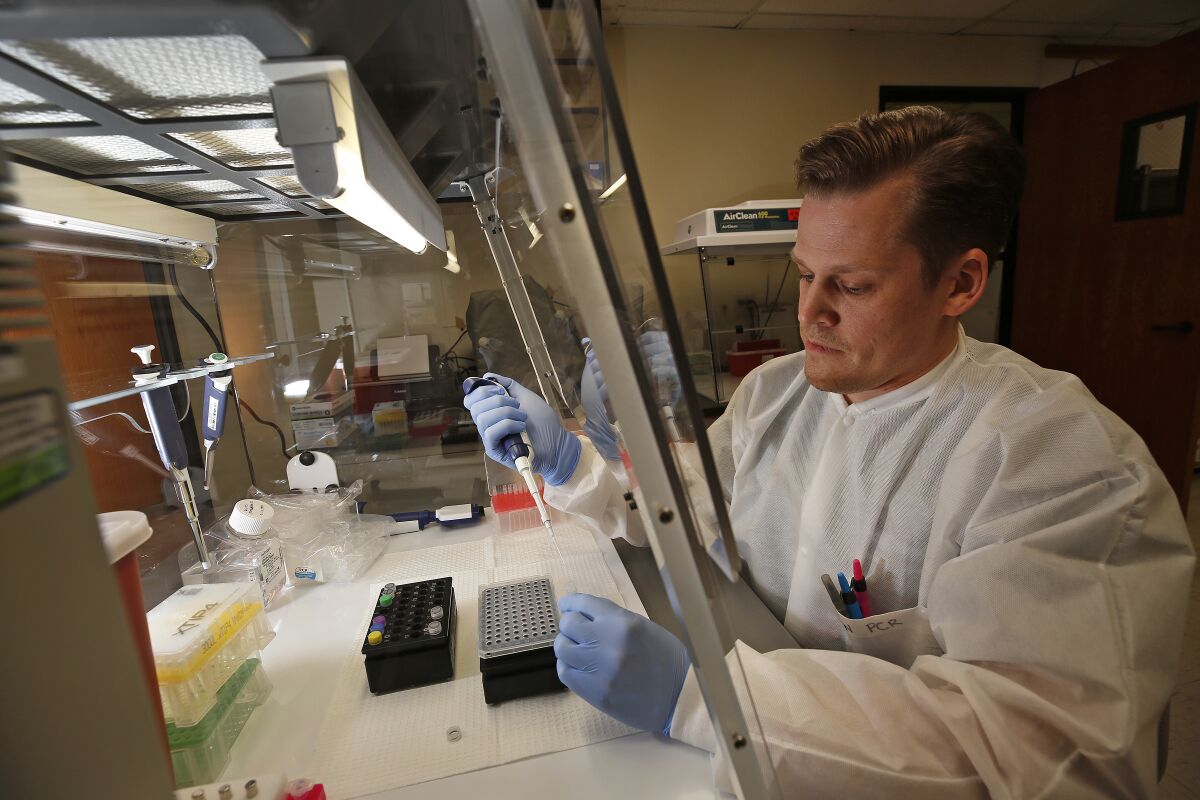 Brian Bowland, a senior clinical lab specialist in microbiology for UCLA Health, preps a mix for testing of the COVID-19 coronavirus.