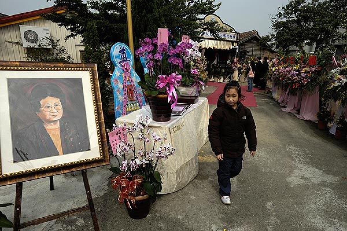 A great-grandchild of Lin Chin-Lien at Lin's funeral in Taiwan. A portrait of the family matriarch stands outside the family home where her funeral was held.