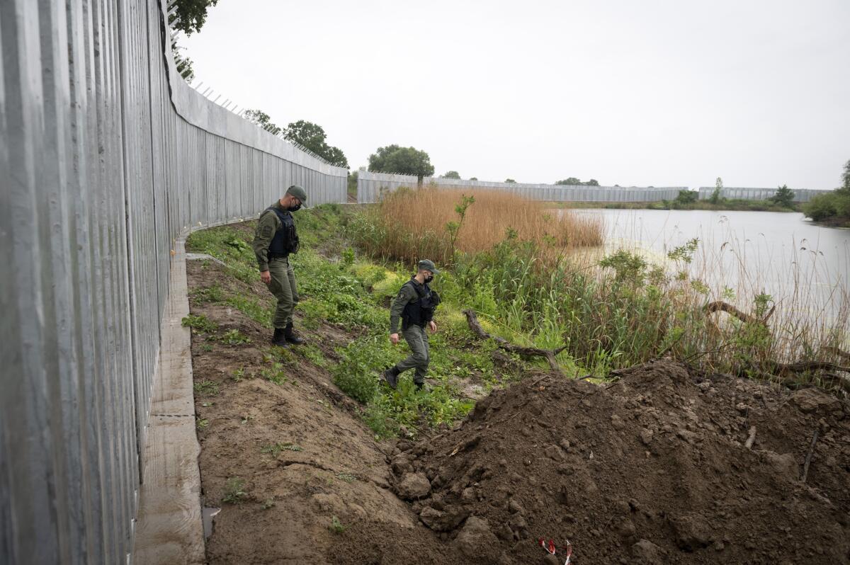 Policemen patrol alongside a steel wall at Evros river at the Greek - Turkish border, Greece.