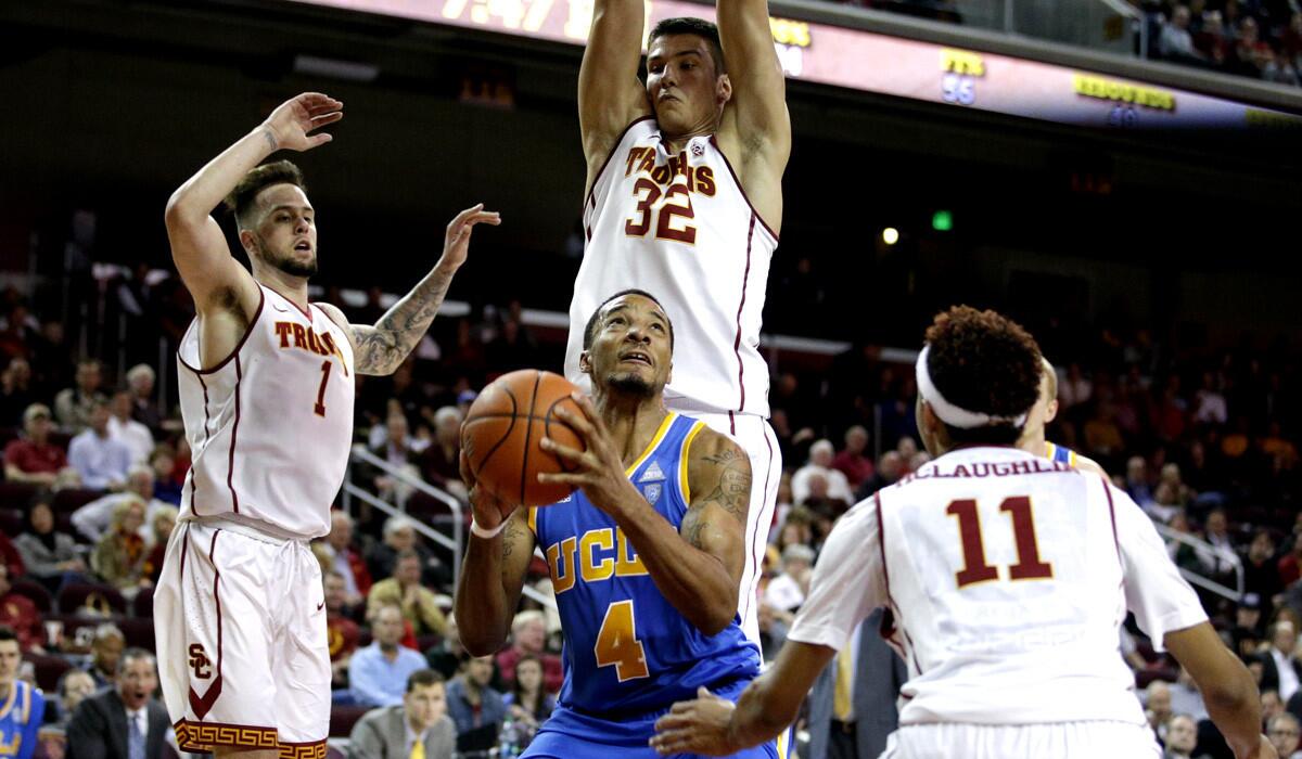 UCLA's Norman Powell, bottom center, looks to shoot as he is guarded by USC's Katin Reinhardt, left, Nikola Jovanovic, center, and Jordan McLaughlin during the Bruins' 83-66 victory over the Trojans on Jan. 14.