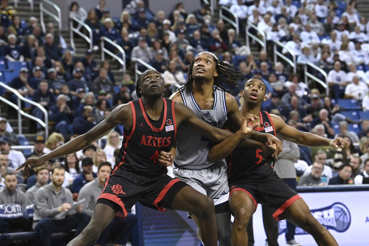 Nevada's Tré Coleman is squeezed between San Diego State's Jay Pal (4) and Lamont Butler (5).