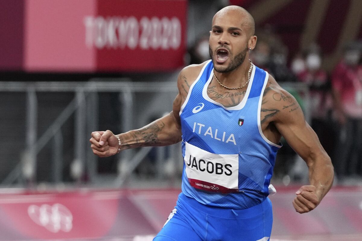Lamont Jacobs of Italy crosses the finish line to win the men's the 100-meter final at the 2020 Summer Olympics, Sunday, Aug. 1, 2021, in Tokyo. (AP Photo/Matthias Schrader)