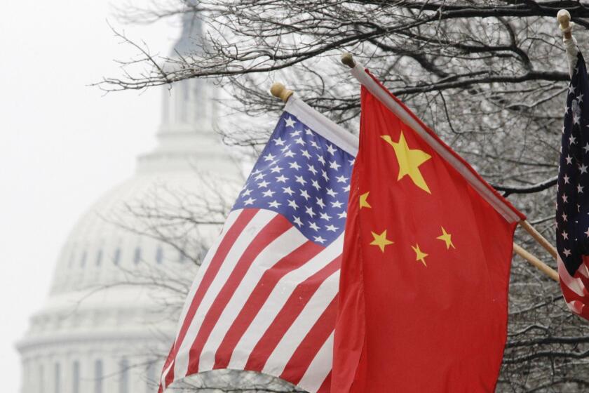 The Capitol dome is seen at rear as Chinese and U.S. flags are displayed in Washington, Tuesday, Jan. 18, 2011, ahead of the arrival of China's President Hu Jintao for a state visit hosted by President Barack Obama. (AP Photo/Charles Dharapak) ORG XMIT: DCCD105
