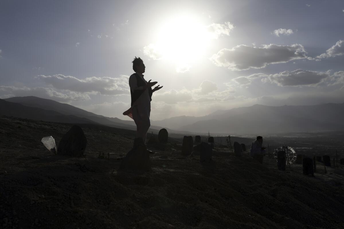 Afghan man prays in cemetery