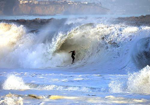 A lone surfer rides a 20-foot wave at the Wedge, an internationally-known spot for surfing and bodyboarding in Newport Beach.