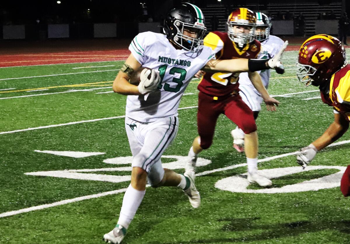 Costa Mesa's Marley Boynton (13) tries to run past Estancia in the Battle for the Bell football game on Friday.