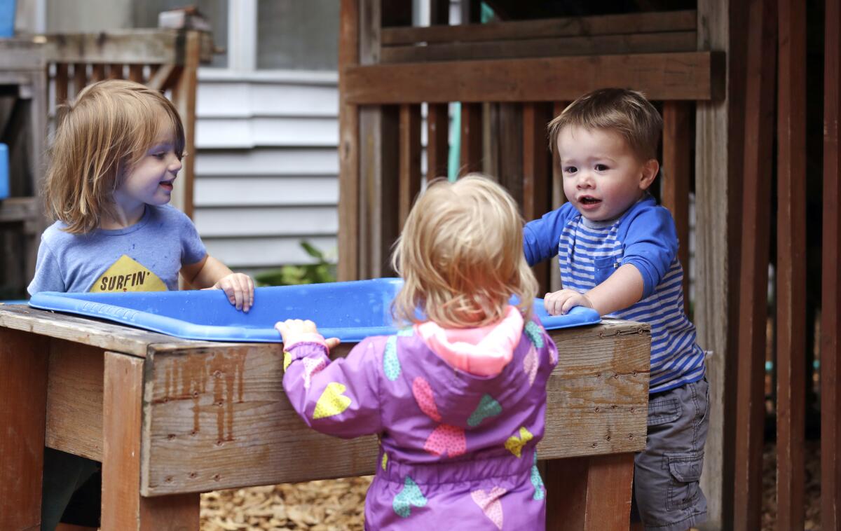 Three children play at a child-care center. 