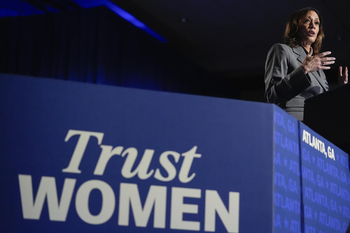 Vice President Kamala Harris speaks with the words "Trust women" in the foreground.