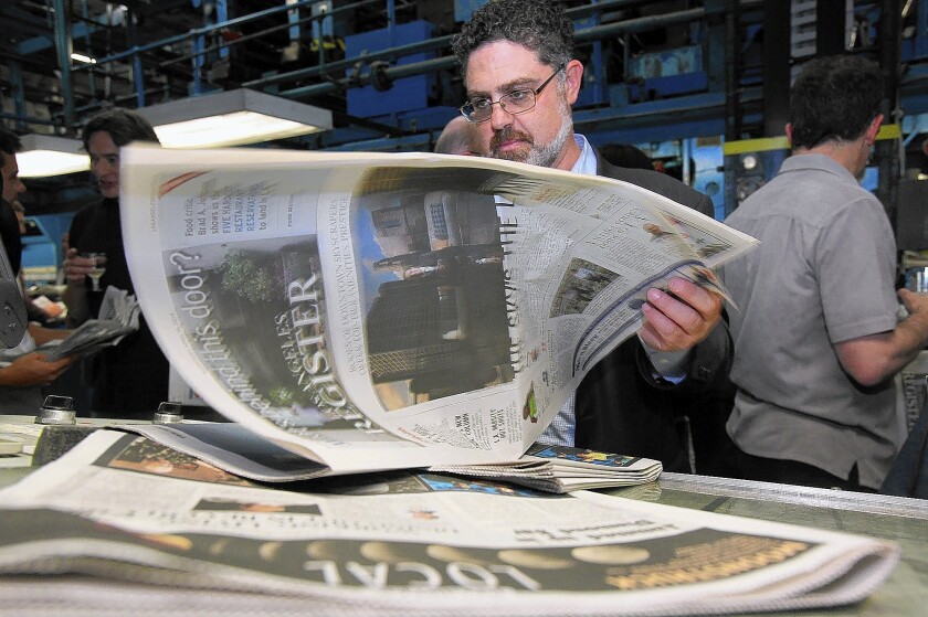 Eric Spitz, co-owner of Freedom Communications, peruses one of the first copies of the Los Angeles Register's inaugural edition to roll off the presses April 16, 2014.