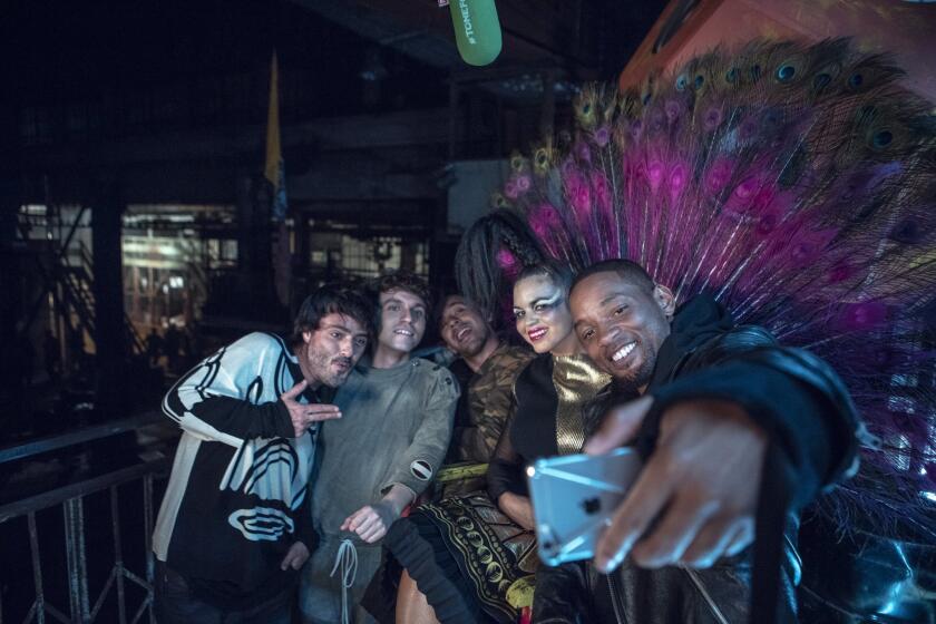 Members of Bomba Estéreo, from left, Simon Mejía, Julián Salazar, Andrés Zea and vocalist Liliana Saumet, pose for a selfie with Will Smith, who appears on a remix for the Colombian band's song "Fiesta." The musicians will pair up again for a performance at the Latin Grammys.