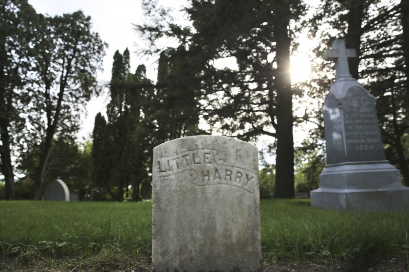 A headstone of a child who at died in the late 1800s at the Home for Destitute Children, in Burlington, Vt., is shown Wednesday, Sept. 21, 2022. Volunteers recently restored about 50 of the gravestones, resetting, straightening and cleaning them. (AP Photo/Lisa Rathke)
