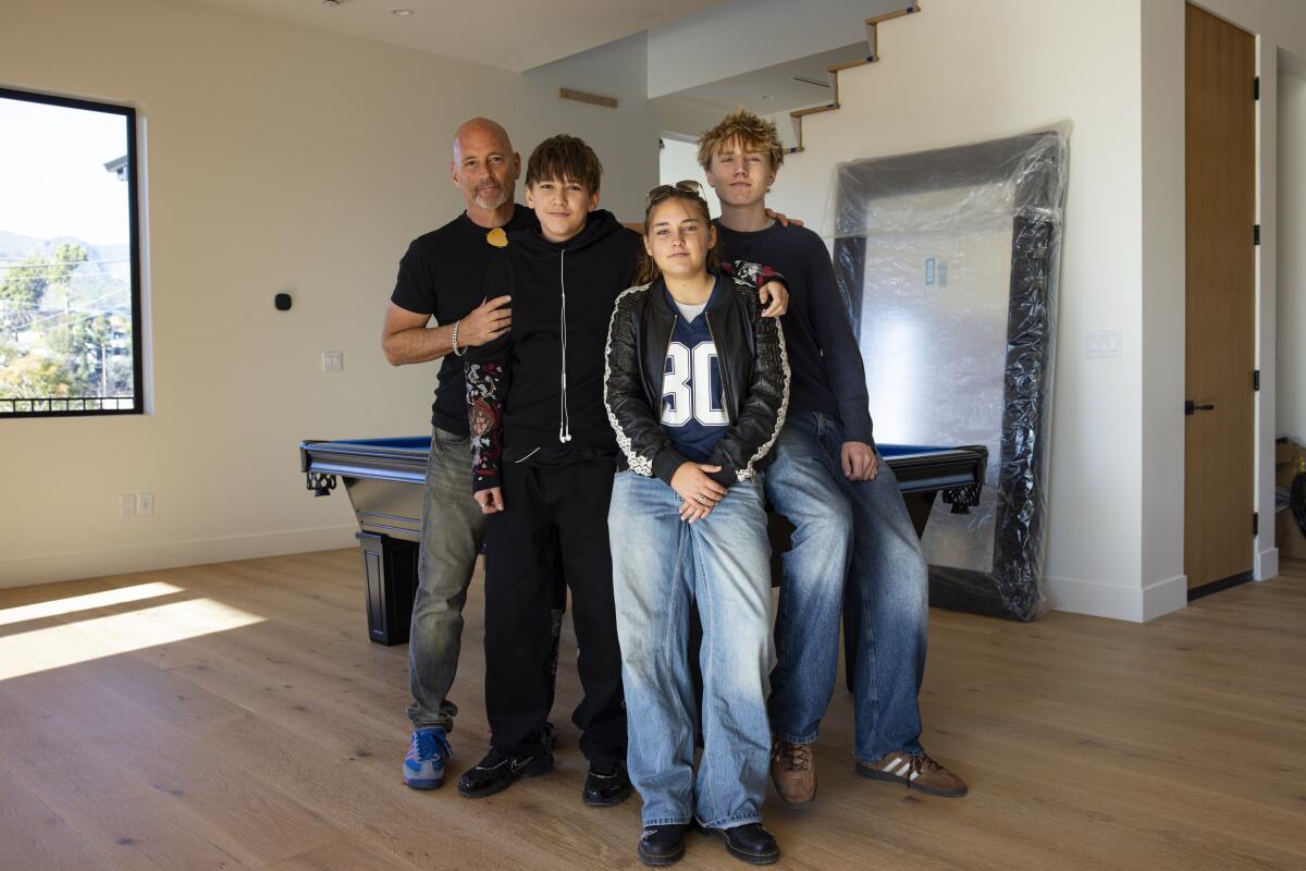 Craig Forrest and his family standing near a billiards table