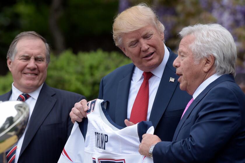 FILE - In this April 19, 2017 file photo, President Donald Trump is presented with a New England Patriots jersey from Patriots owner Robert Kraft, right, and head coach Bill Belichick during a ceremony on the South Lawn of the White House in Washington, where the Patriots were honored for their Super Bowl LI victory. In addition to the jersey, the team confirmed on Tuesday, Aug. 22, 2017, that Kraft decided after the team's visit to also have a Super Bowl championship ring made for Trump. (AP Photo/Susan Walsh, File)