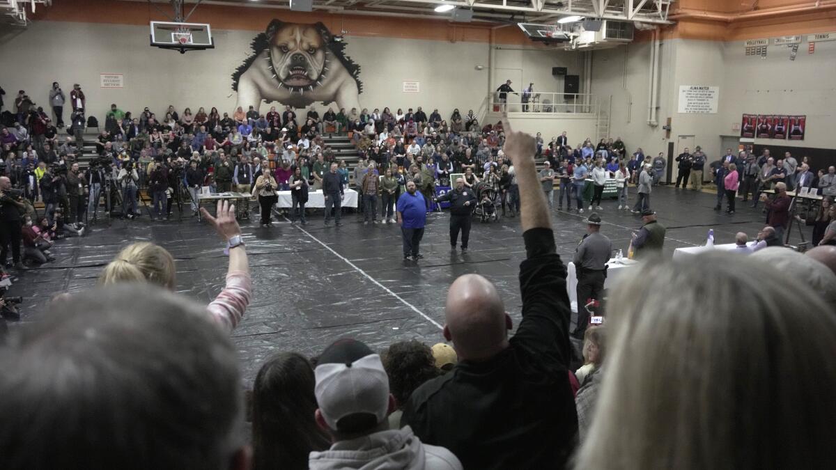 Crowded public meeting at a high school 