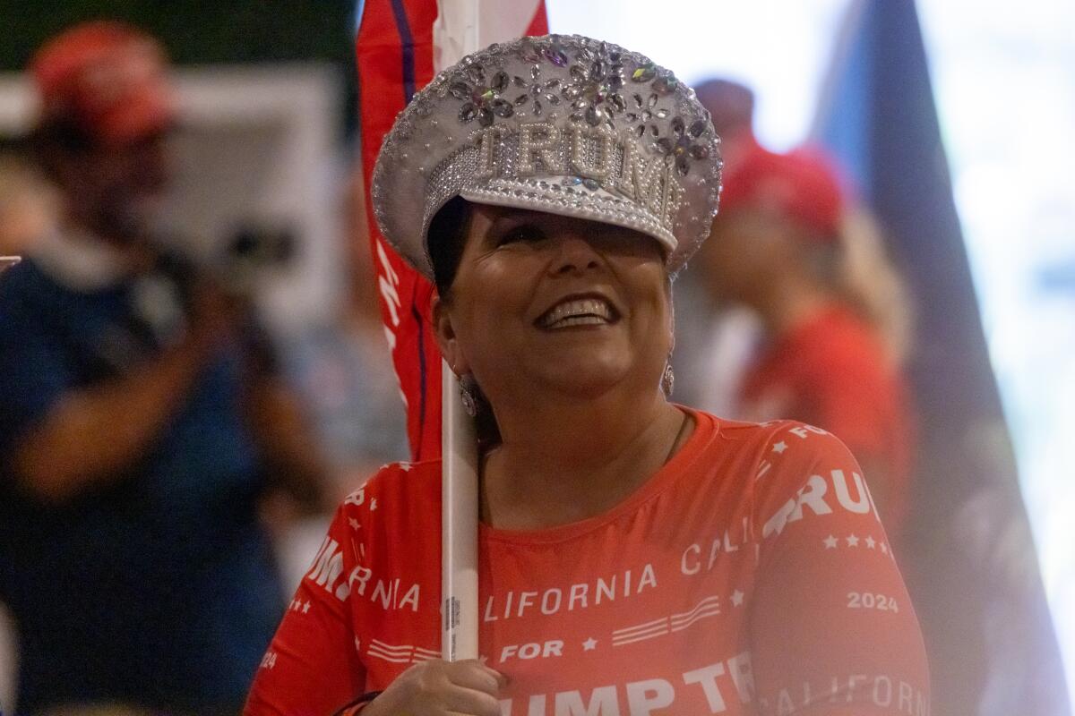 A close shot of woman wearing a "California for Trump" dress and a glittery Trump hat