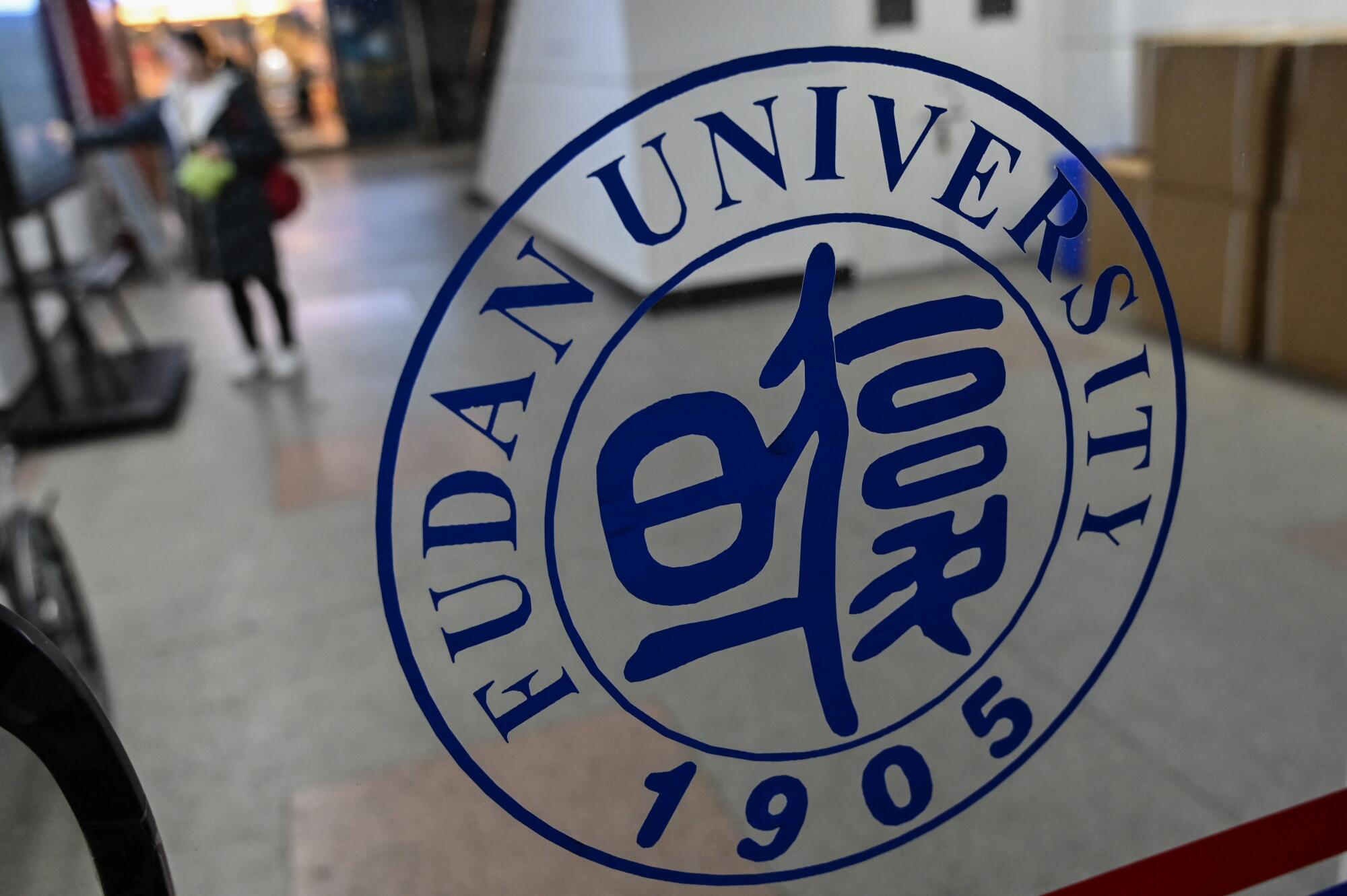 A Fudan University logo is seen on a glass door on the campus in Shanghai.