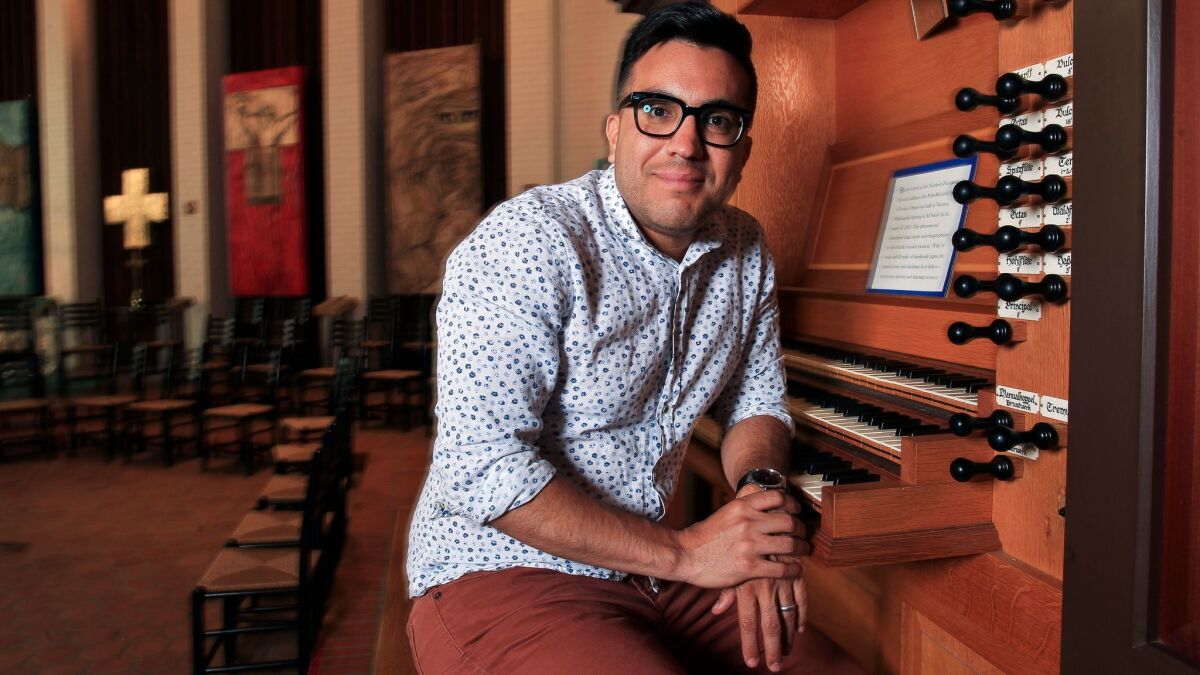 Ruben Valenzuela, founder and artistic director of the Bach Collegium San Diego, sits at the organ at All Soul's Episcopal Church in Point Loma, where he is the music director.