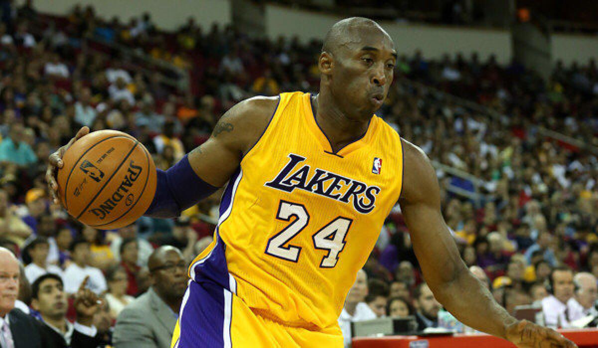 The Lakers' Kobe Bryant controls the ball against the Golden State Warriors on Oct. 7, 2012.