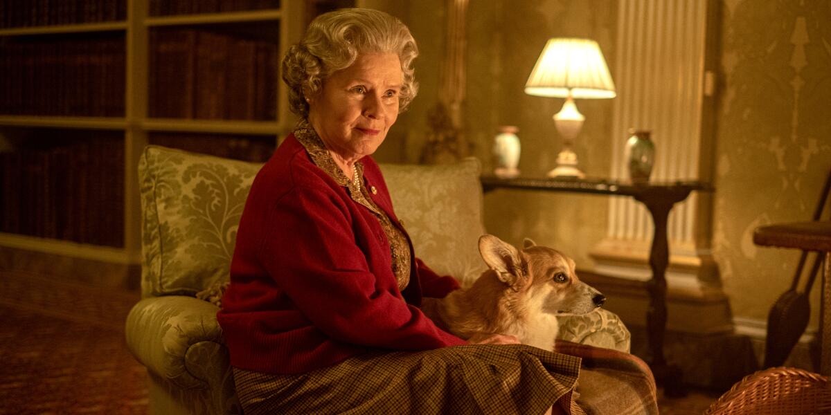 Imelda Staunton as Queen Elizabeth II sits on a chair with one of her corgis in Season 6 of 'The Crown.'
