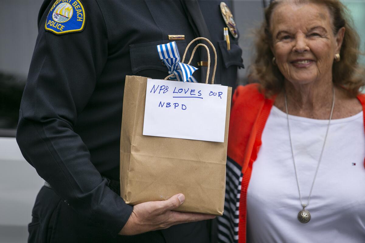 Dotty McDonald, 91, bestows $6,000 in gift cards Monday to Newport Beach Police Department Chief Jon Lewis, June 28, 2021.