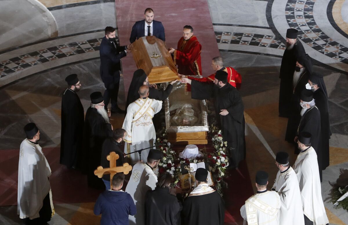 Serbian Orthodox Church leaders open the coffin of Patriarch Irinej during a procession in Belgrade, Serbia.