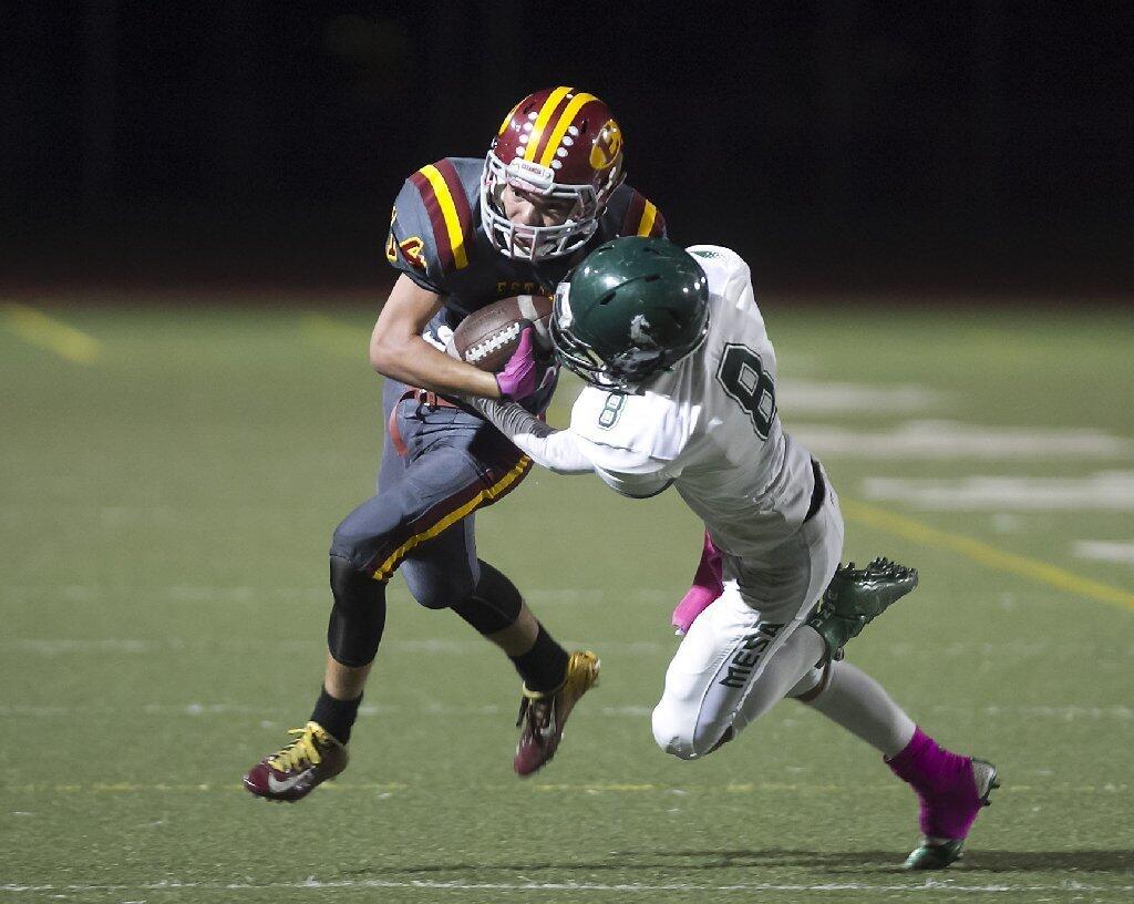 Estancia High's Trevor Brown, left, tries to avoid a tackle by Costa Mesa's Justin Figueroa.