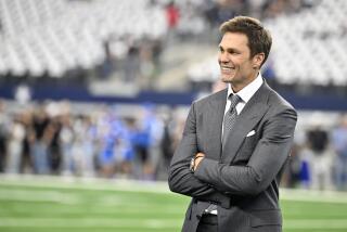 Analyst Tom Brady smiles with folded arms on the field