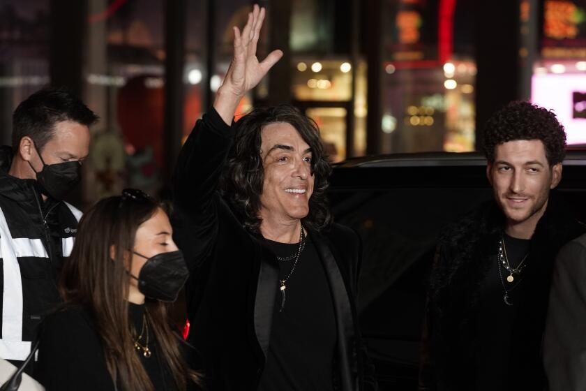 KISS singer Paul Stanley waves to the crowd as he arrives with his son Evan, right, at the premiere of the film "Studio 666," Wednesday, Feb. 16, 2022, at the TCL Chinese Theatre in Los Angeles. (AP Photo/Chris Pizzello)