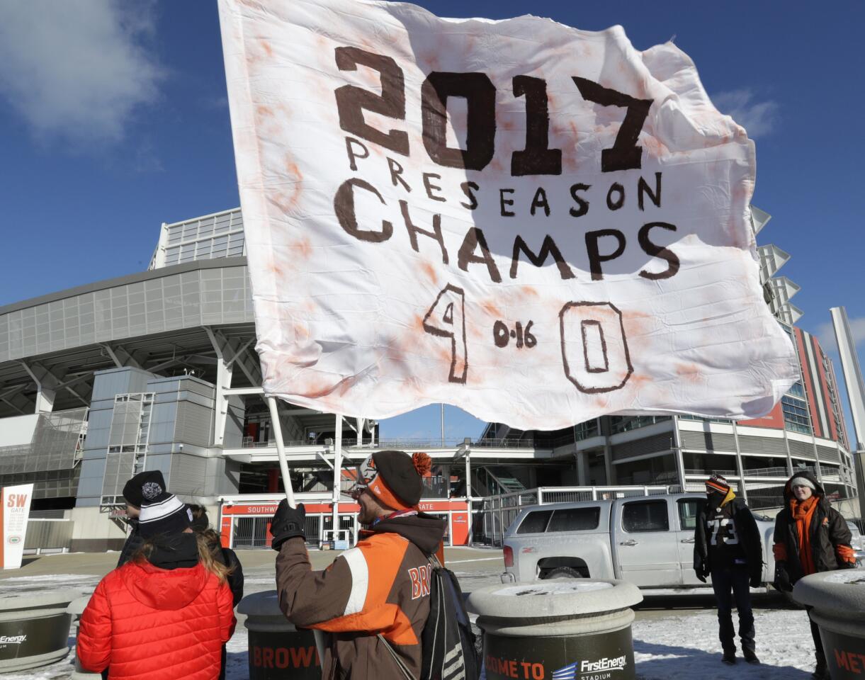 Matt Hughes holds up a flag during the "Perfect Season" parade on Saturday in Cleveland. The Browns became the second team in NFL history to lose 16 games in a season.
