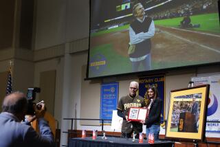 San Diego CA - April 18: San Diego Rotary Club President Michael Brunker, left, presents Sheel Seidler with a plaque honoring her late husband, Padres owner Peter Seidler posthumously honored as Mr. San Diego by the club at Liberty Station on Thursday, April 18, 2024. (K.C. Alfred / The San Diego Union-Tribune)