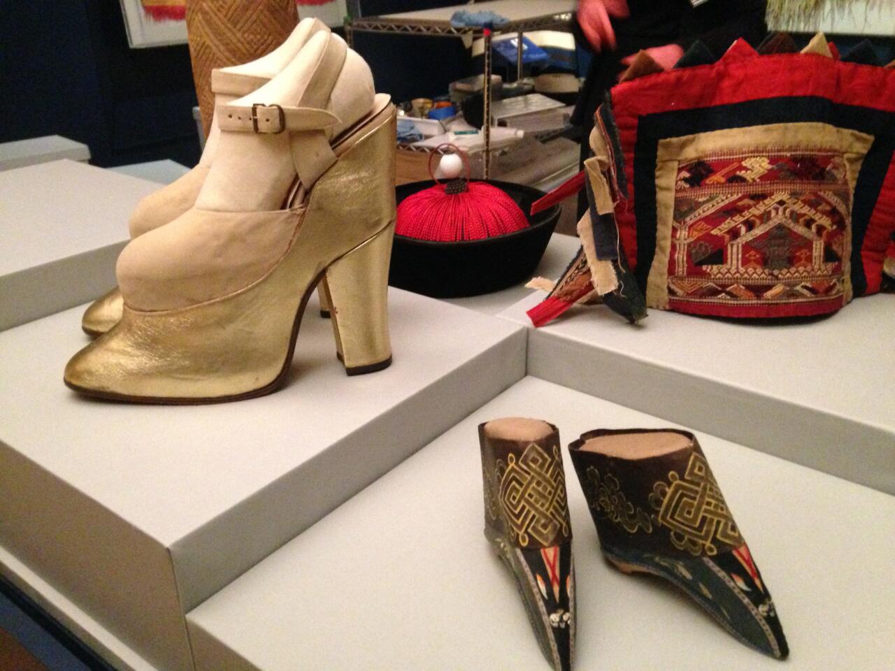 Platform shoes worn by actress Mae West in the 1950s were used to increase her height by more than 8 inches. In the foreground,shoes for a Manchu noblewoman from China that date to the late 19th century. Both are on display at the Foggy Bottom museum that opened Monday.
