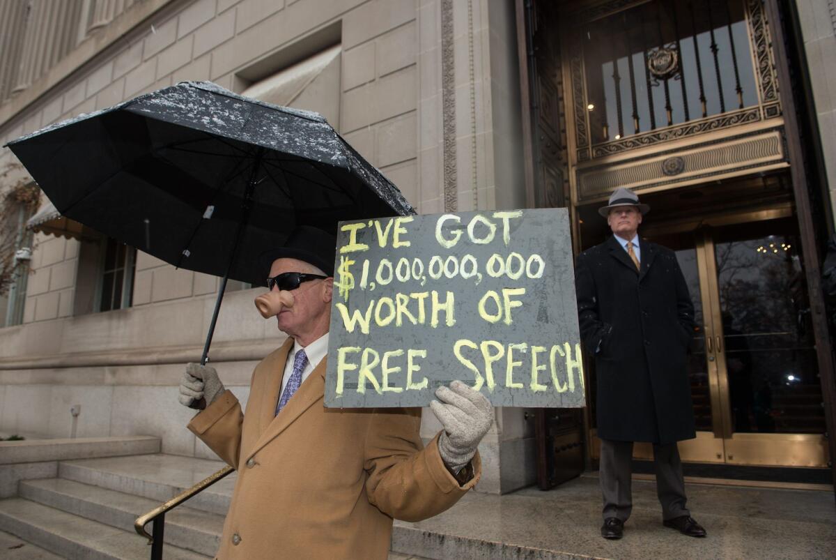 A demonstrator holds a sign outside the U.S. Chamber of Commerce during a rally against the Supreme Court's decision five years ago in favor of Citizens United, which allows private citizens and corporations to make unlimited donations for political campaigns.