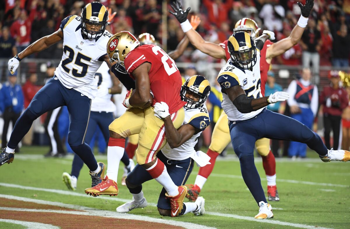 49ers running back Carlos Hyde scores a touchdown in front of Rams from left, T.J. McDonald, Lamarcus Joyner and Alex Ogletree in the 1st quarter.